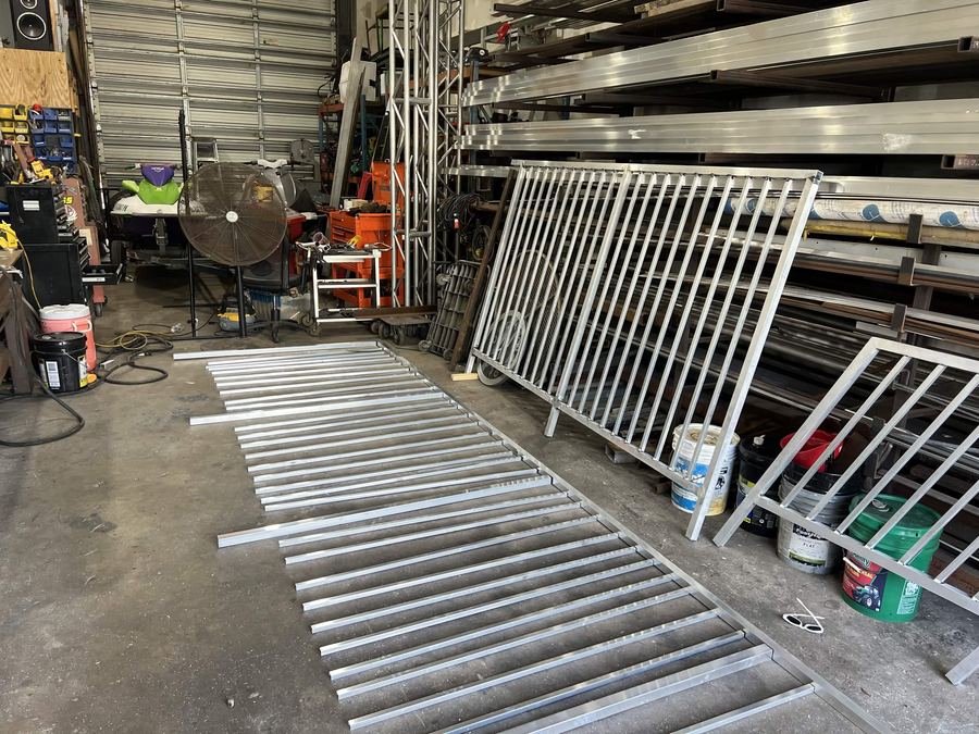 Fabrication shop with aluminum railing panels staged on the floor