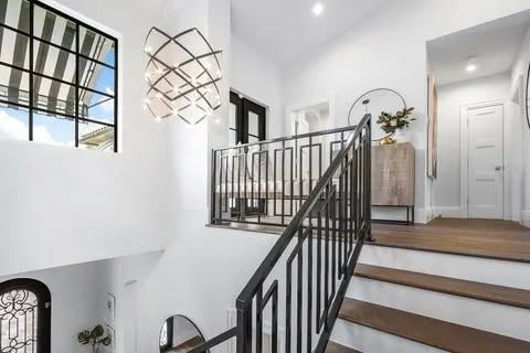 Two story staircase with black metal railing and landing guardrail